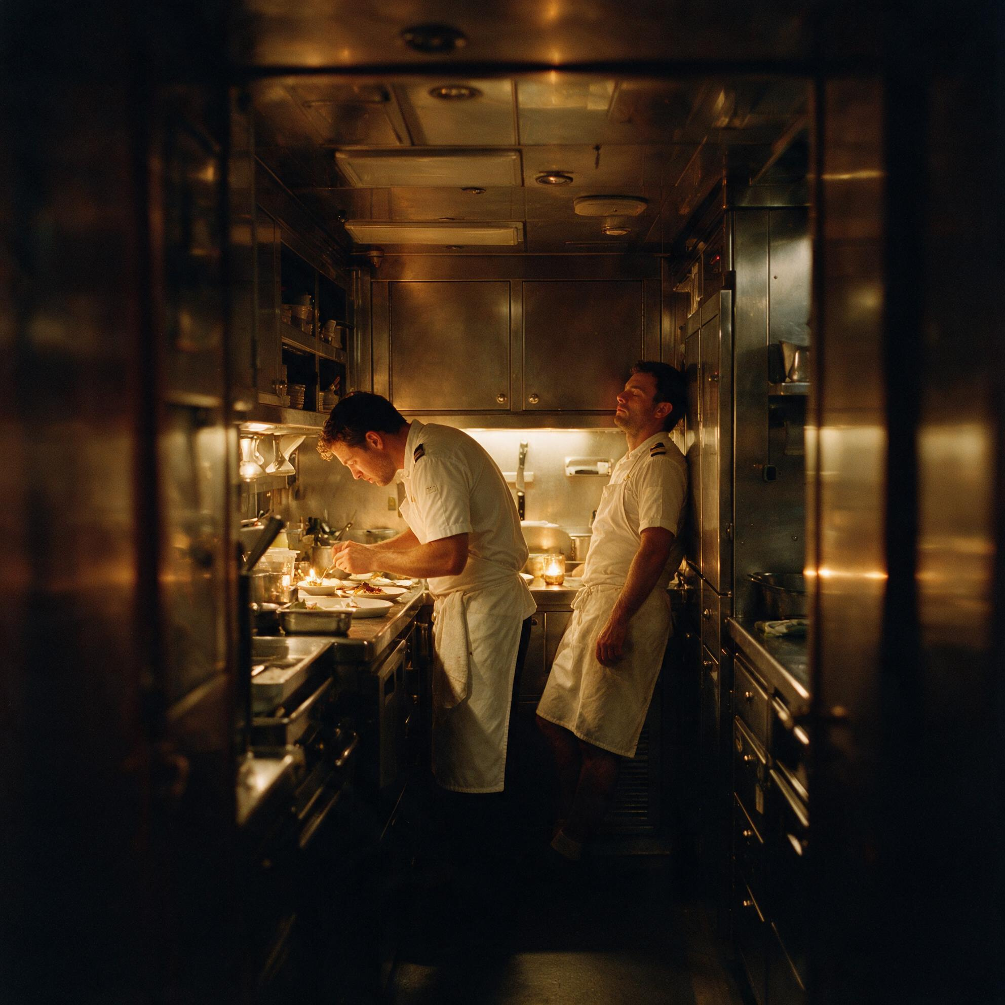 Crew working in a dim galley late at night, mid-season